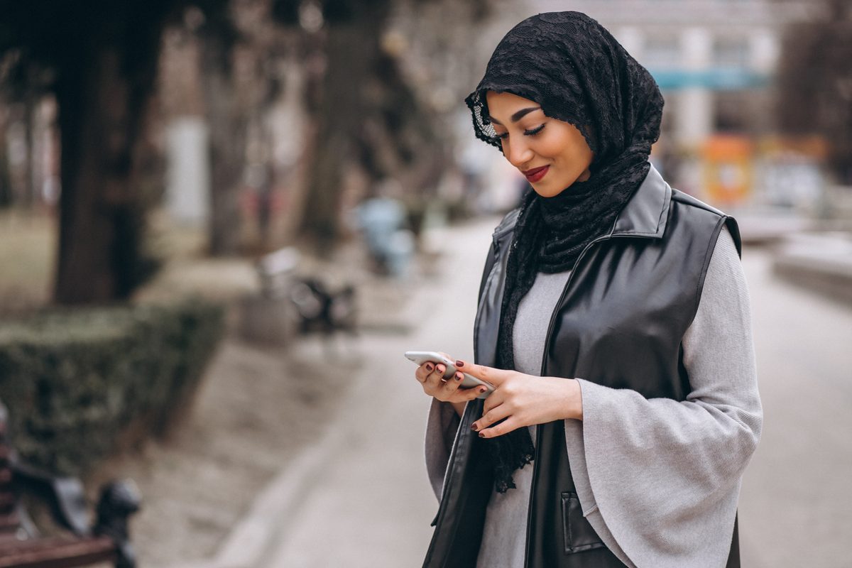 A woman checking her phone while walking outside